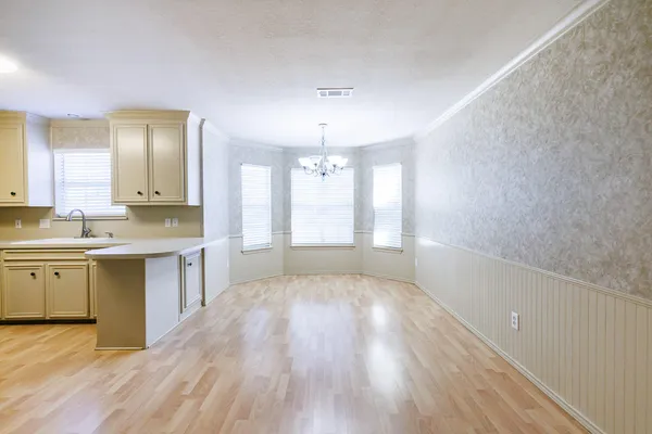 a large kitchen with a wooden floor and white appliances
