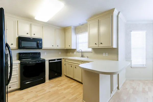 a kitchen with stainless steel appliances granite countertop a stove a sink and a microwave