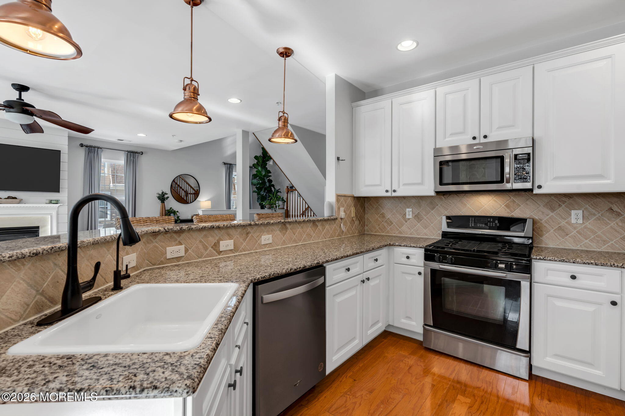712 Abby Road Middletown, NJ 07748 - Photo 17 of 44 a kitchen with stainless steel appliances granite countertop a sink a stove and a wooden floors