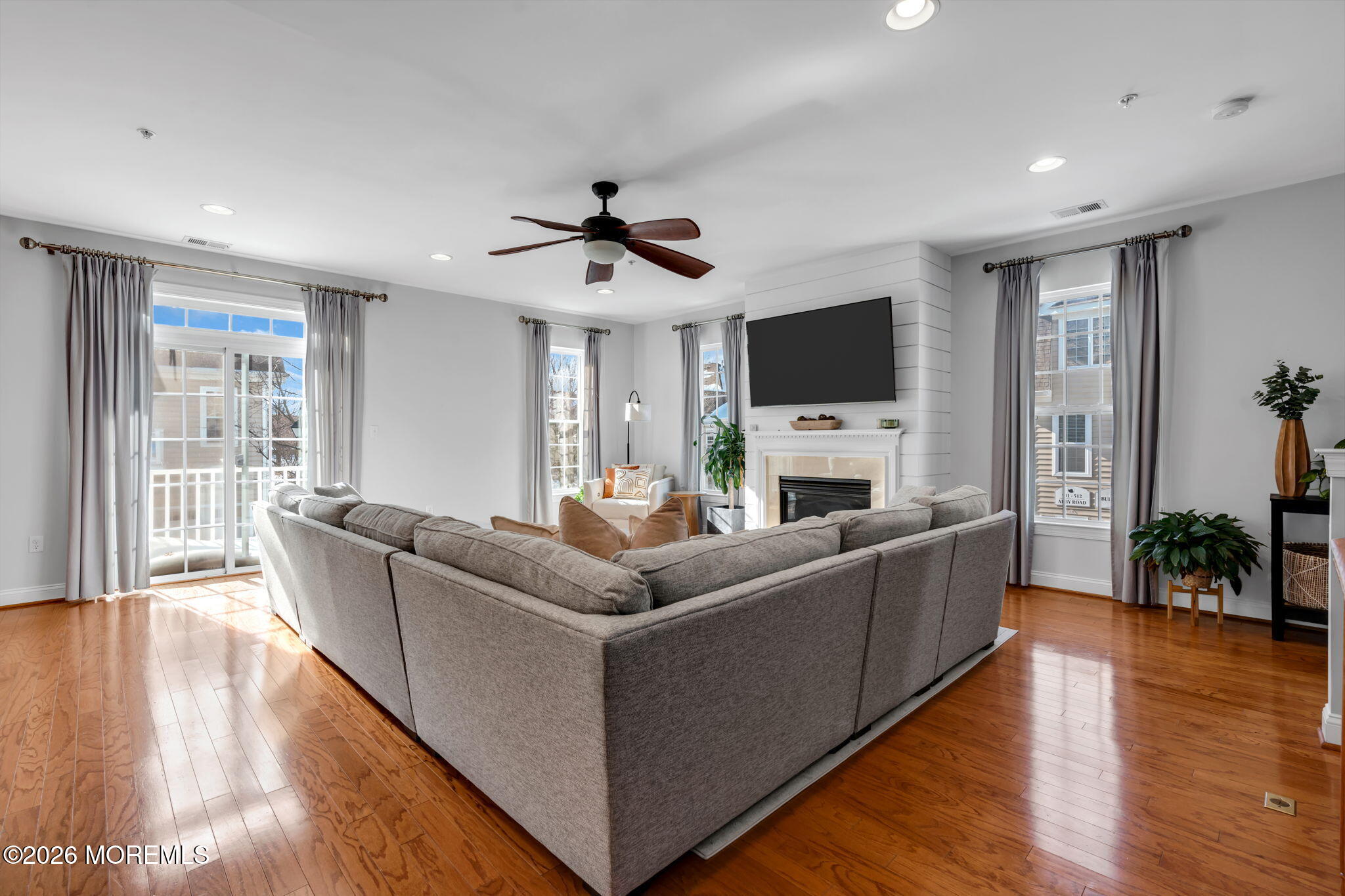 712 Abby Road Middletown, NJ 07748 - Photo 40 of 44 a living room with furniture a fireplace and a flat screen tv