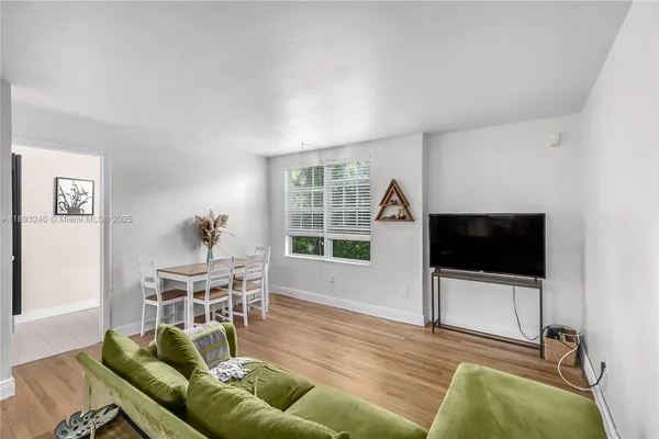 a living room with furniture a flat screen tv and a window