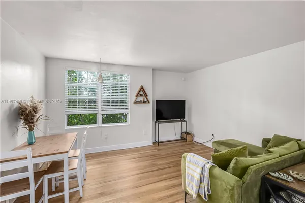 a living room with furniture a flat screen tv and a floor to ceiling window