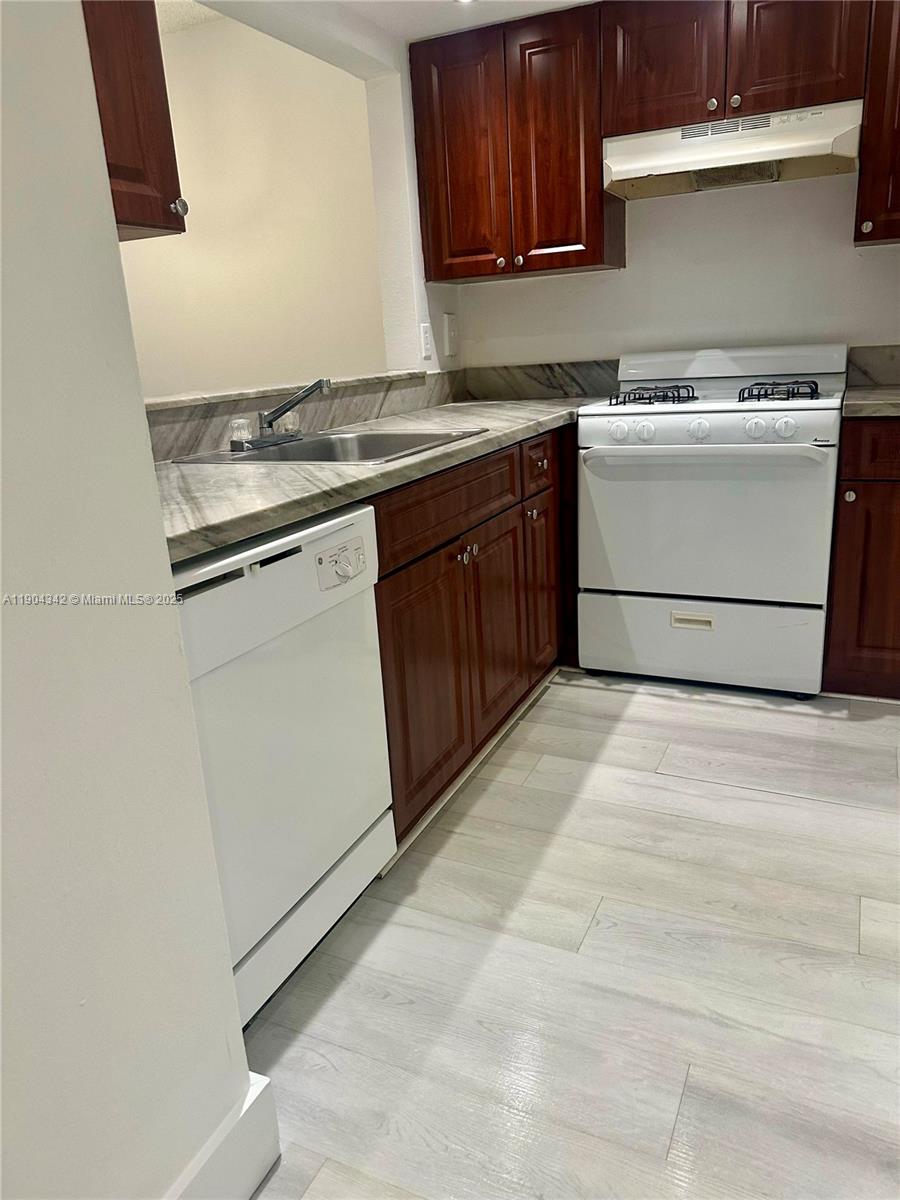 a kitchen with a stove top oven sink and cabinets