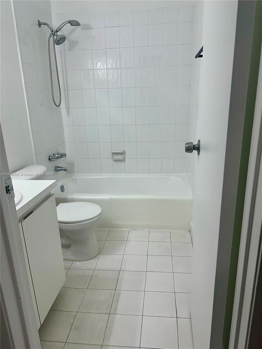 18007 Northwest 68th Avenue, Unit U103 Hialeah, FL 33015 - Photo 7 of 9 a bathroom with a bathtub a toilet a sink and shower