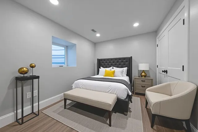 a bedroom with a bed and wooden floor