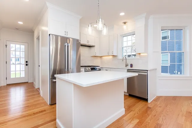 a kitchen with a sink a center island cabinets and a window