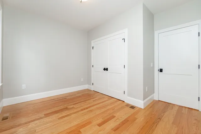 a view of empty room with wooden floor