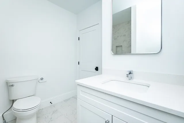 a bathroom with a sink toilet and mirror