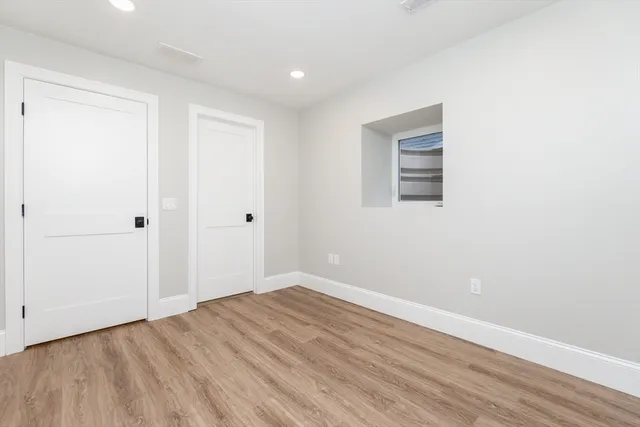 a view of empty room with wooden floor