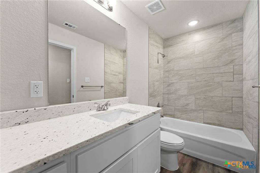 313 Elbert Lane, Unit B Harker Heights, TX 76548 - Photo 5 of 10 a bathroom with a granite countertop sink a toilet and bathtub
