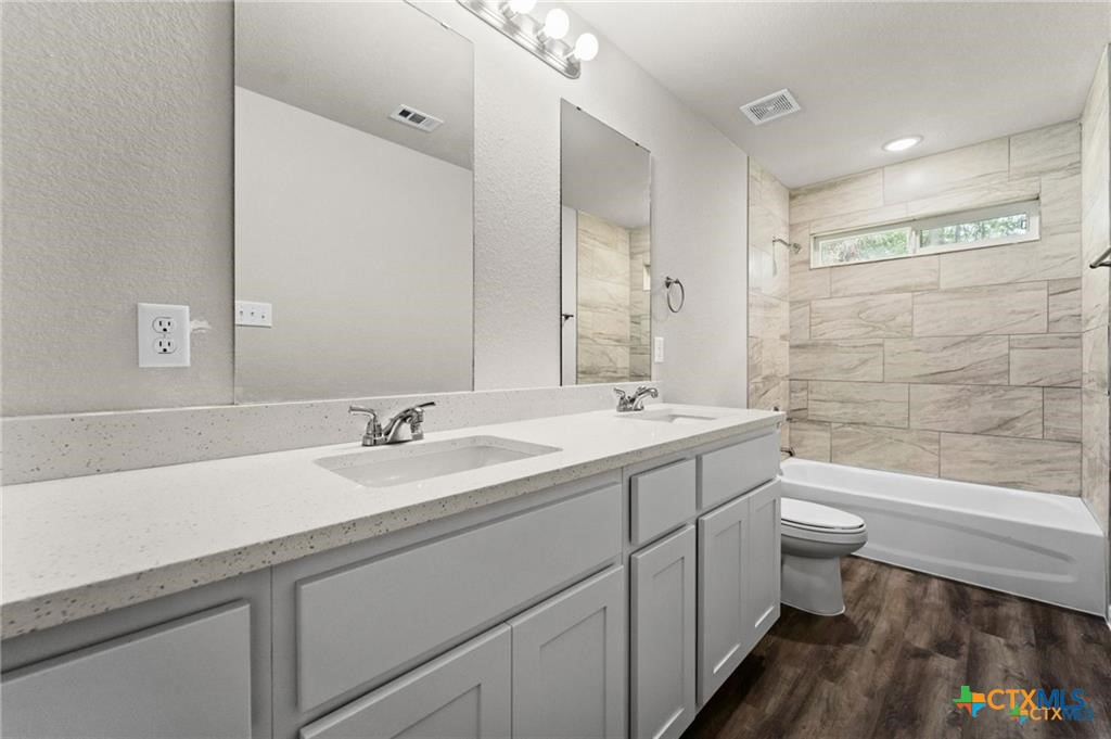 313 Elbert Lane, Unit B Harker Heights, TX 76548 - Photo 9 of 10 a bathroom with a double vanity sink toilet and shower