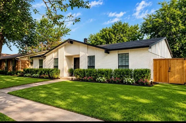 a front view of a house with a garden