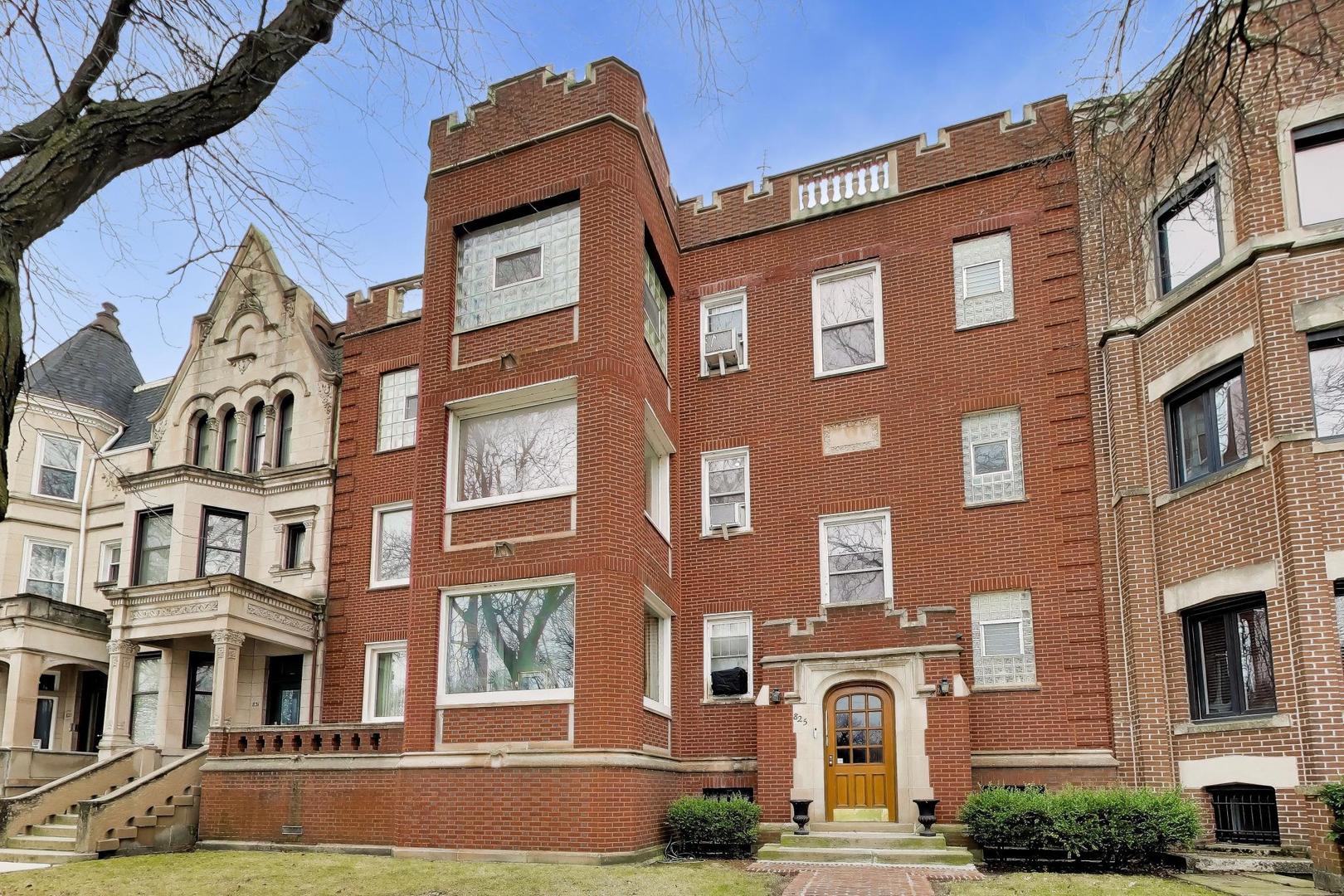 a front view of a residential apartment building with a yard