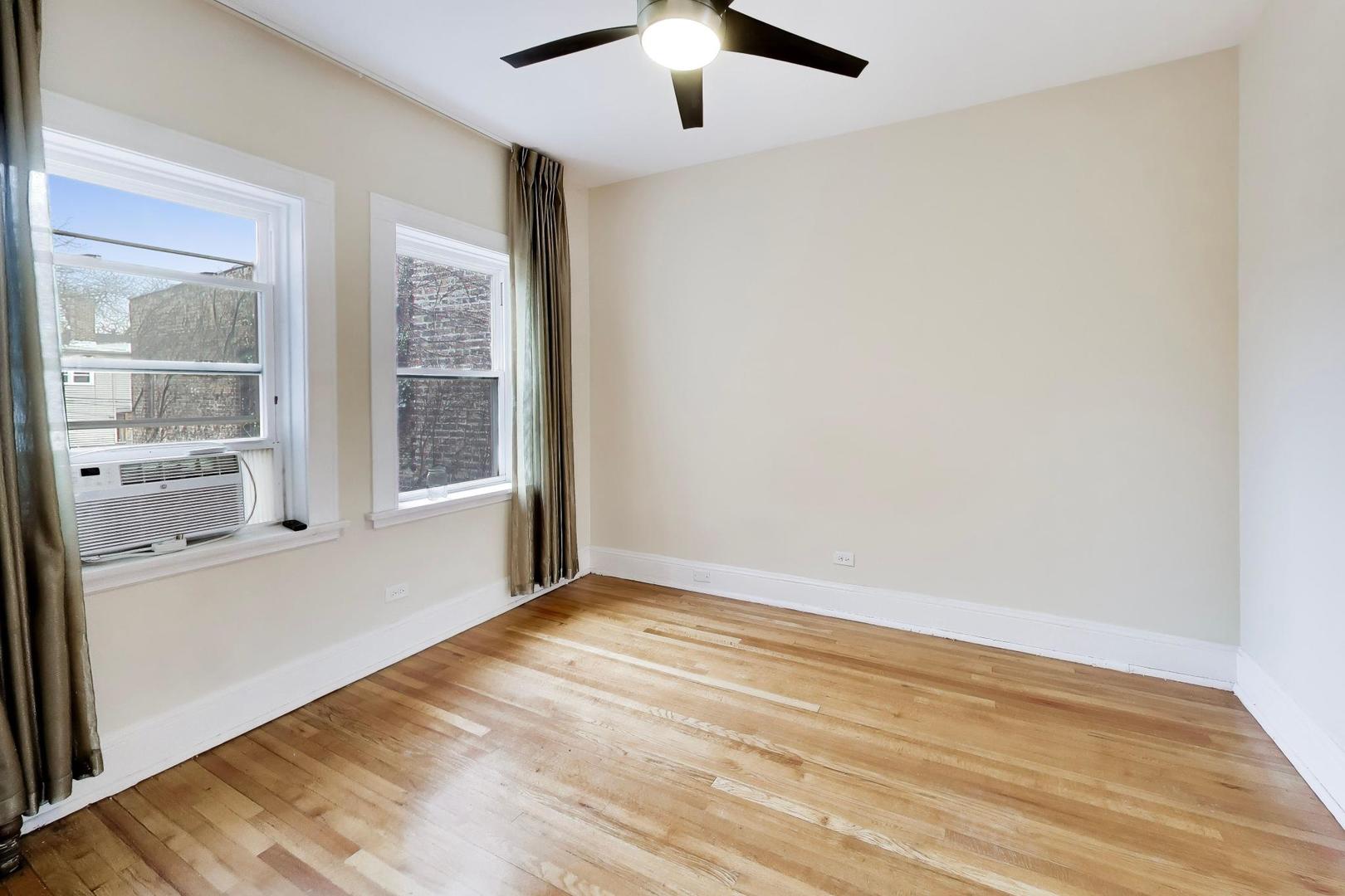 825 East Drexel Square, Unit 2 Chicago, IL 60615 - Photo 15 of 25 an empty room with wooden floor and windows