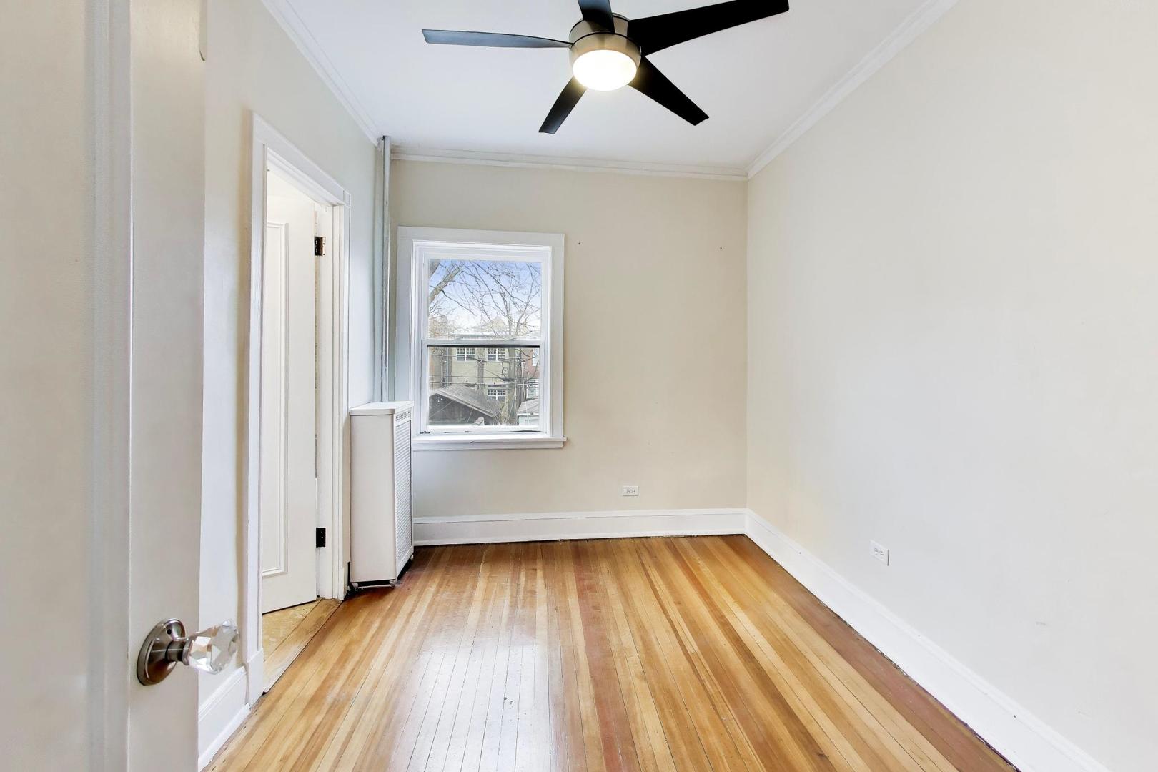 825 East Drexel Square, Unit 2 Chicago, IL 60615 - Photo 19 of 25 a view of empty room with wooden floor and fan