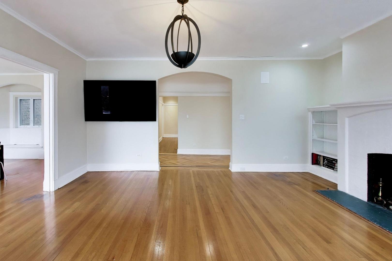 825 East Drexel Square, Unit 2 Chicago, IL 60615 - Photo 6 of 25 a view of a livingroom with wooden floor and a flat screen tv