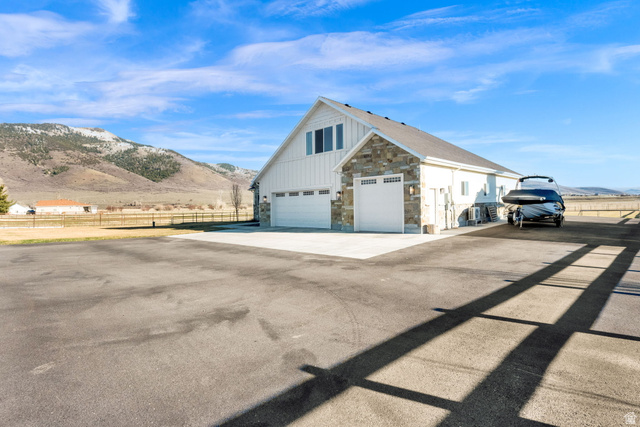 352 East Boulderville Road Oakley, UT 84055 - Photo 40 of 62 View of side of property with stone siding, a mountain view, driveway, and board and batten siding