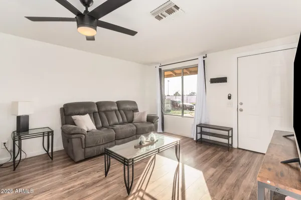 a living room with furniture and a wooden floor