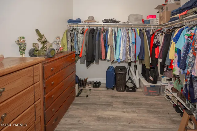 a view of walk in closet with clothes