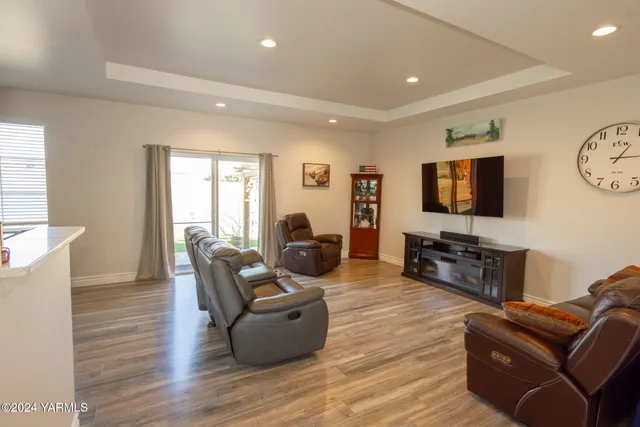 a living room with furniture a flat screen tv and wooden floor
