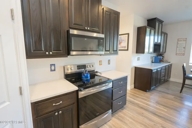 a kitchen with stainless steel appliances a sink cabinets and wooden floor
