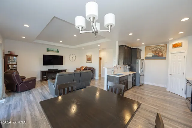 a living room with furniture a flat screen tv and kitchen view