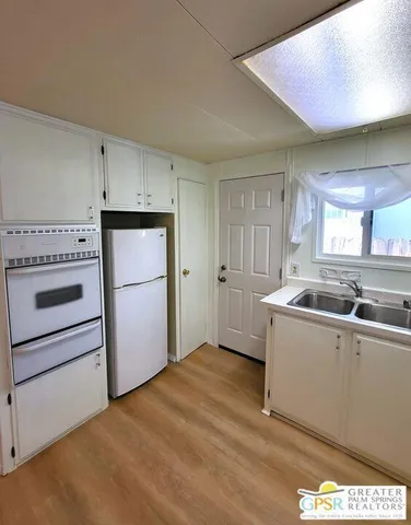 a kitchen with a refrigerator and white cabinets