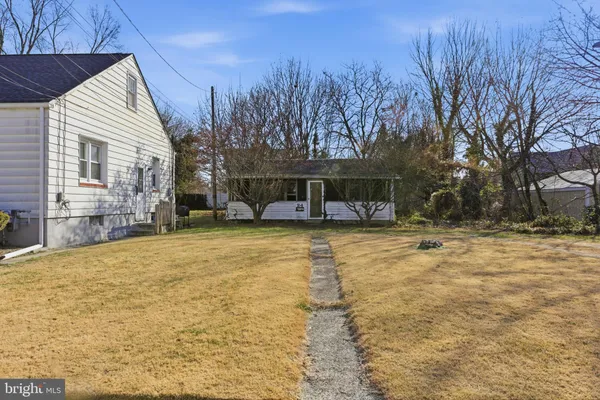 a front view of house with yard and trees in the background