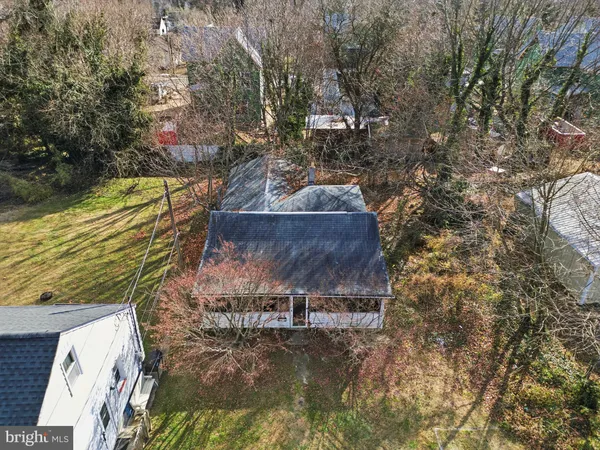 an aerial view of a residential houses with outdoor space and trees