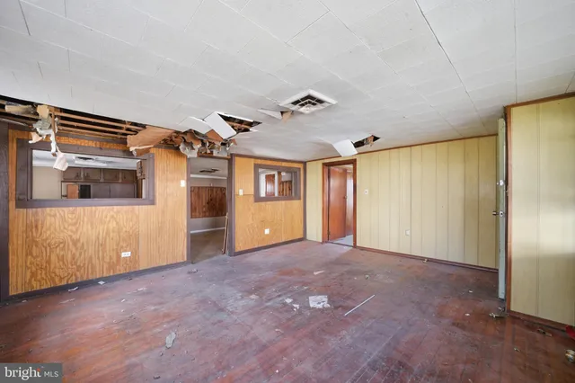 a view of a big room with wooden floor and windows