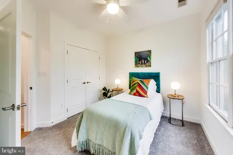 a bedroom with a bed and a painting on the wall