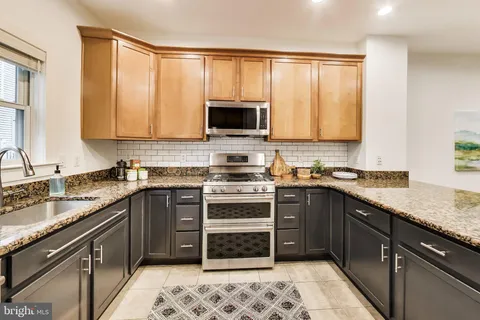 a kitchen with a sink stove top oven and cabinets