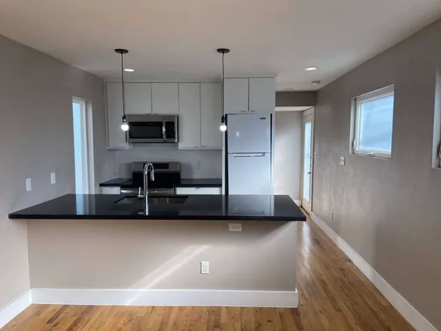 a view of a kitchen with a sink and a refrigerator
