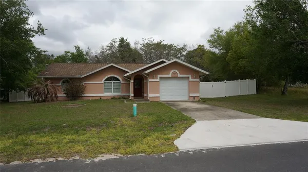 a front view of a house with a yard and trees
