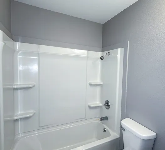a bathroom with a shower a toilet and sink