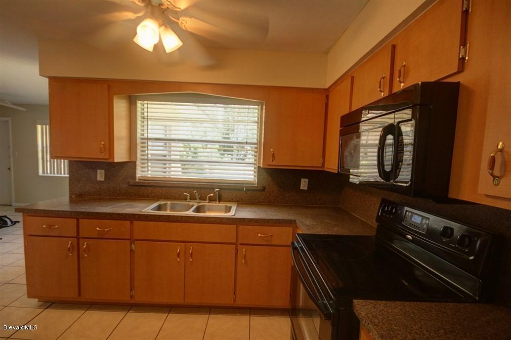 1312 Moss Lane Cocoa, FL 32922 - Photo 14 of 24 a kitchen with a sink a stove and cabinets