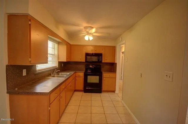 a kitchen with granite countertop a sink and cabinets