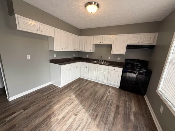 a kitchen with granite countertop a stove and cabinets