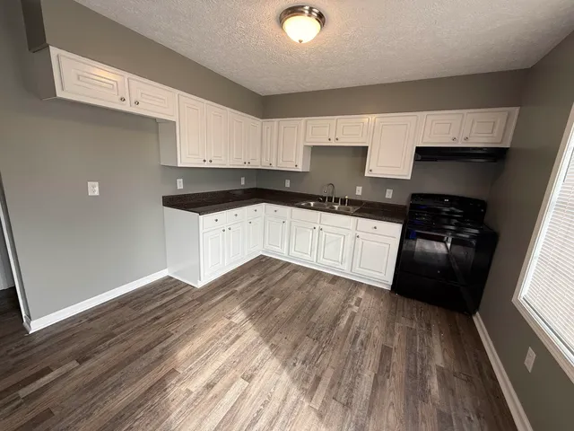 a kitchen with granite countertop a stove and cabinets