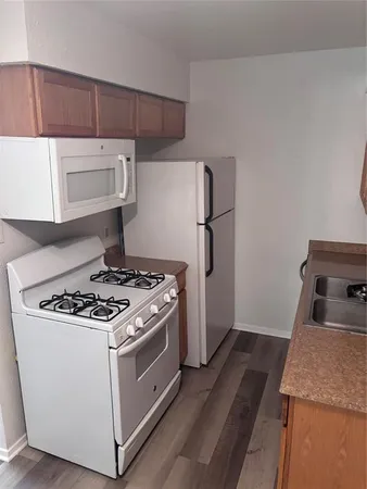 a white stove top oven sitting inside of a kitchen