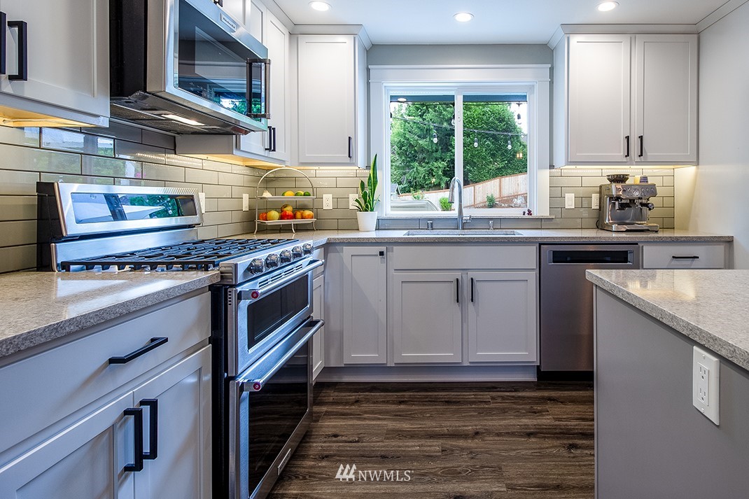 20118 103rd Place Northeast Bothell, WA 98011 - Photo 16 of 40 a kitchen with stainless steel appliances granite countertop a stove a sink and a microwave