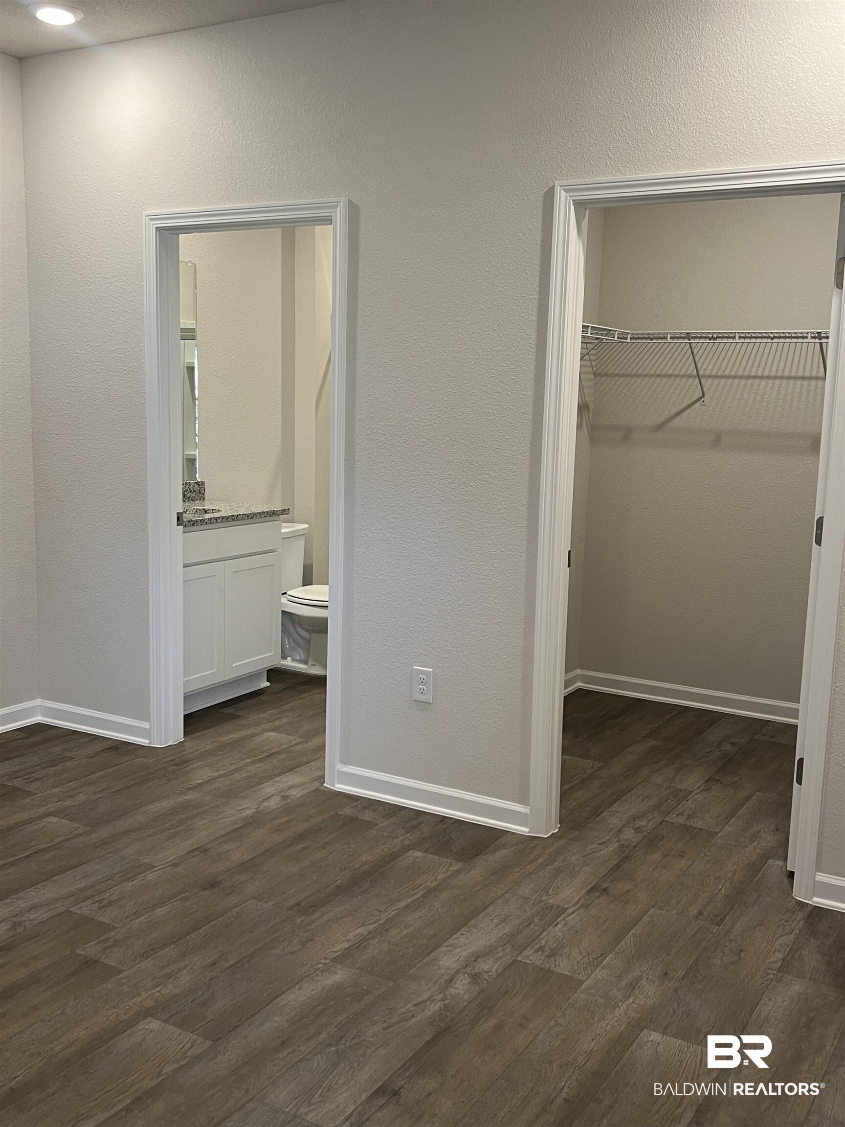 12829 Patriot Way Daphne, AL 36527 - Photo 26 of 38 Unfurnished bedroom featuring dark hardwood / wood-style flooring, a closet, a walk in closet, and ensuite bathroom