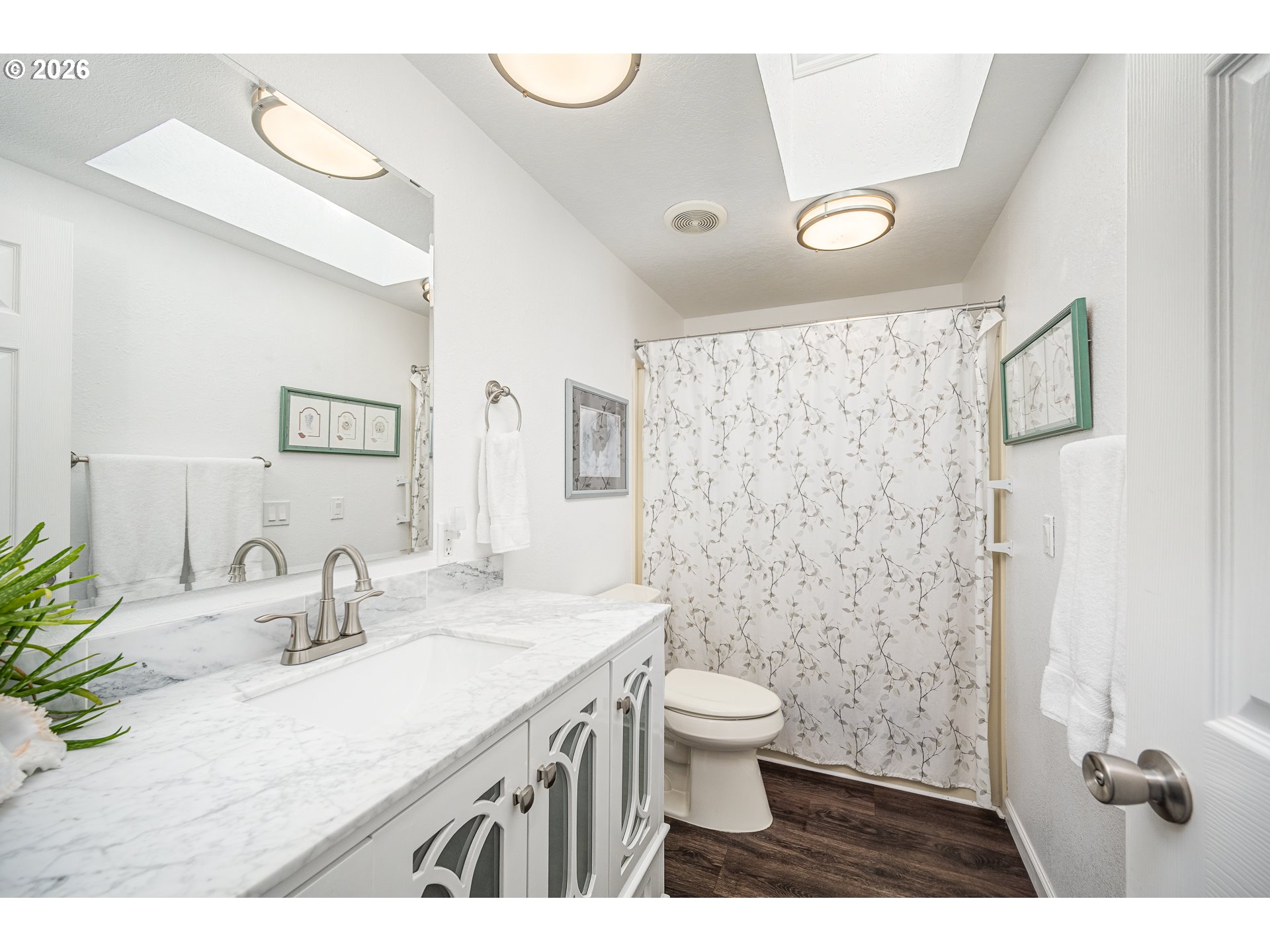 128 Evergreen Lane Florence, OR 97439 - Photo 16 of 34 a bathroom with a granite countertop sink a toilet a mirror and shower curtain