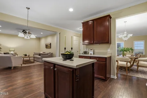 a kitchen with a refrigerator sink cabinets and wooden floor
