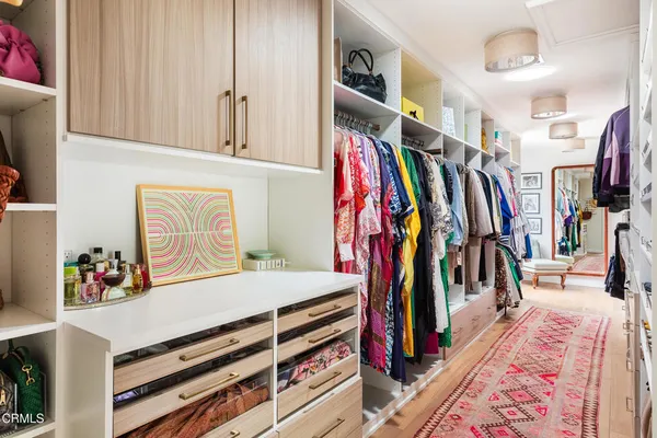 a view of walk in closet with clothes and shoes