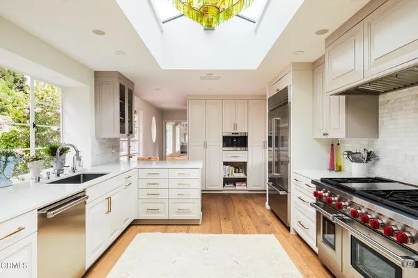 a kitchen with stainless steel appliances a stove a sink and a refrigerator