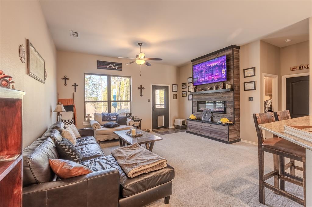 8676 State Highway Edgewood, TX 75117 - Photo 15 of 37 a living room with furniture a fireplace and a flat screen tv