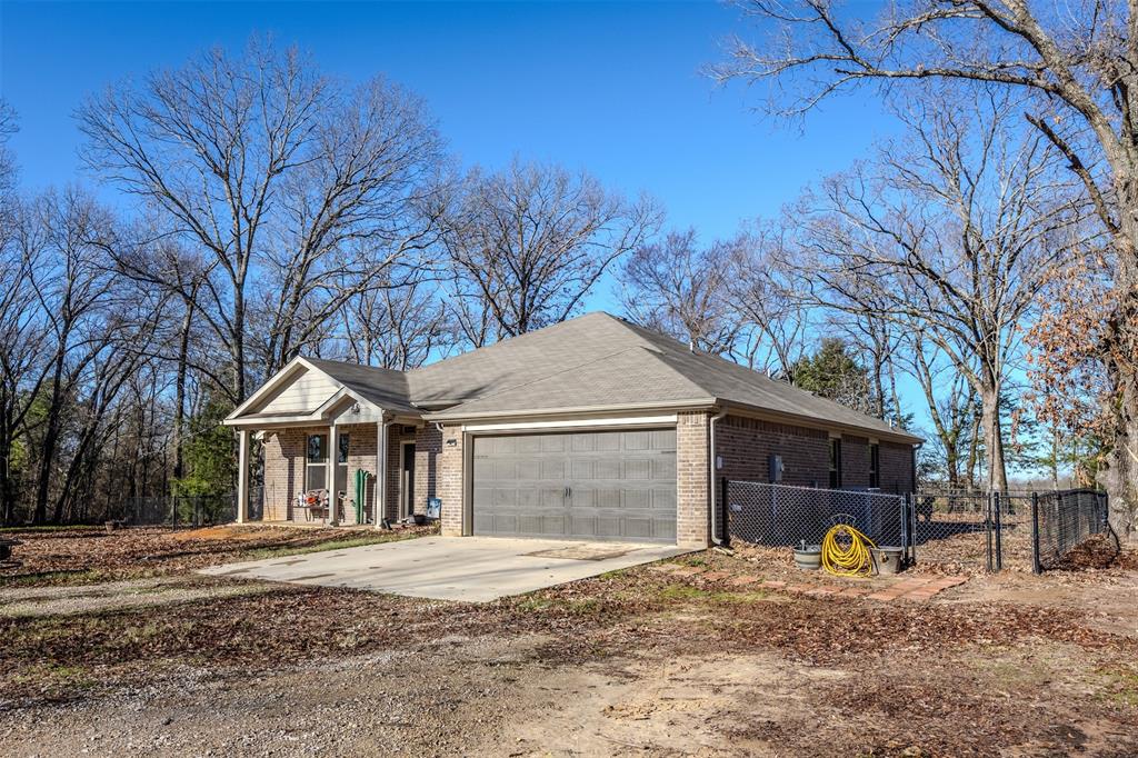 8676 State Highway Edgewood, TX 75117 - Photo 2 of 37 a front view of a house with a yard and garage