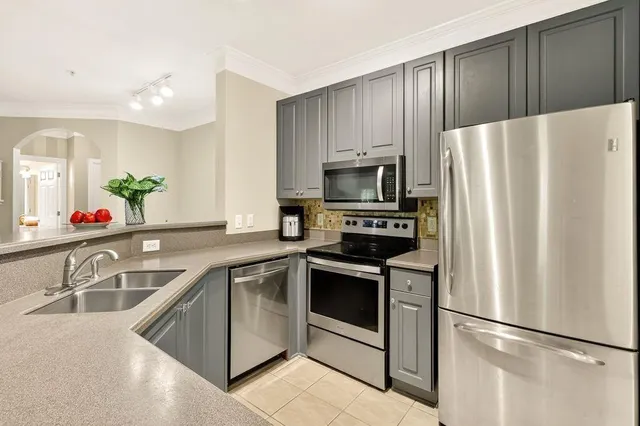 a kitchen with granite countertop stainless steel appliances a refrigerator sink and microwave