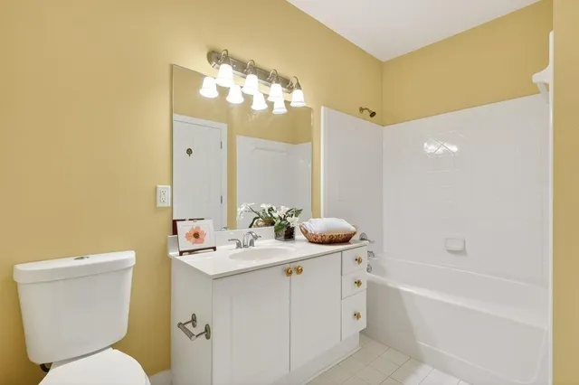 a bathroom with a double vanity sink mirror and toilet